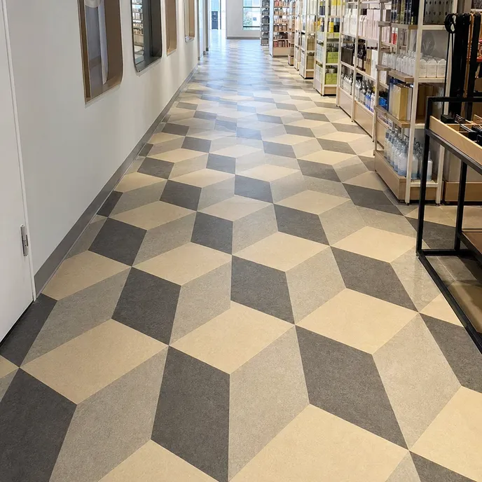 Diamond and rhombus LVT tiles creating three-dimensional optical effects in corridor and retail aisle installations