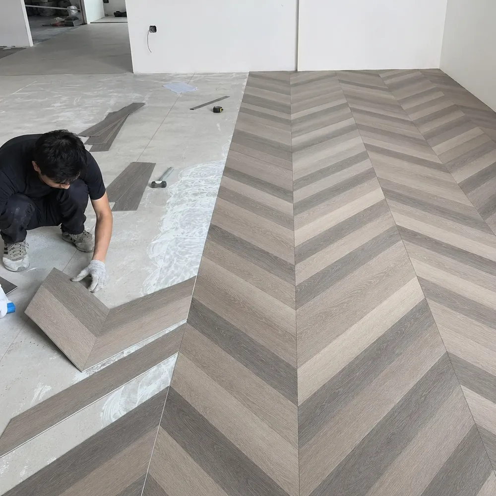 Geometric LVT installation showing chevron pattern alignment and dry-back tile layout process