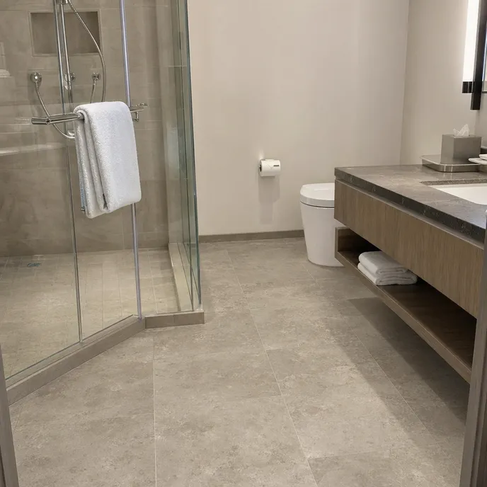 Hotel bathroom with stone-look LVT flooring installed for hospitality renovation