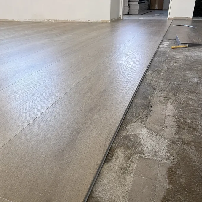 8mm SPC flooring installed over uneven renovation subfloor showing how thick rigid core bridges imperfections