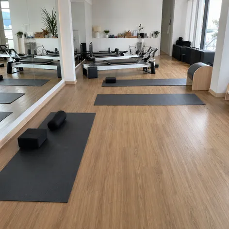 Boutique yoga and pilates studio with premium wood-look SPC flooring in warm tone finish