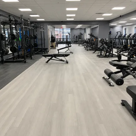Commercial gym chain fitness floor with SPC flooring installed across large open training area