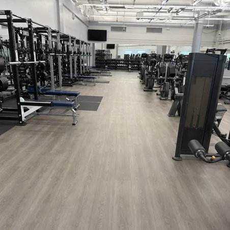 University recreation center large-scale SPC flooring installation across weight room and cardio areas