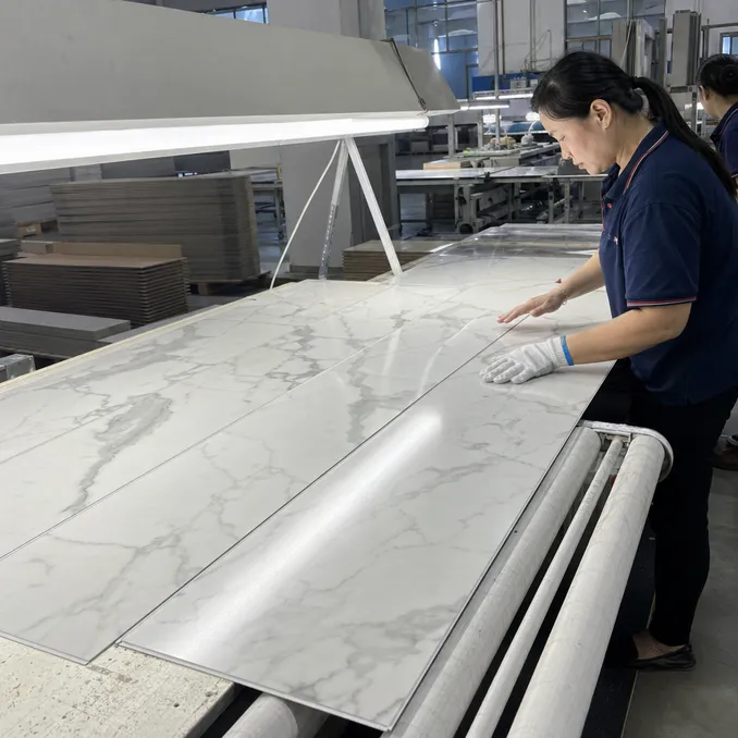 Marble SPC planks under angled lighting during 100% visual inspection at Elefloor factory